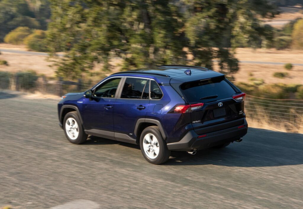 rear left view of blueprint color rav4 driving on road