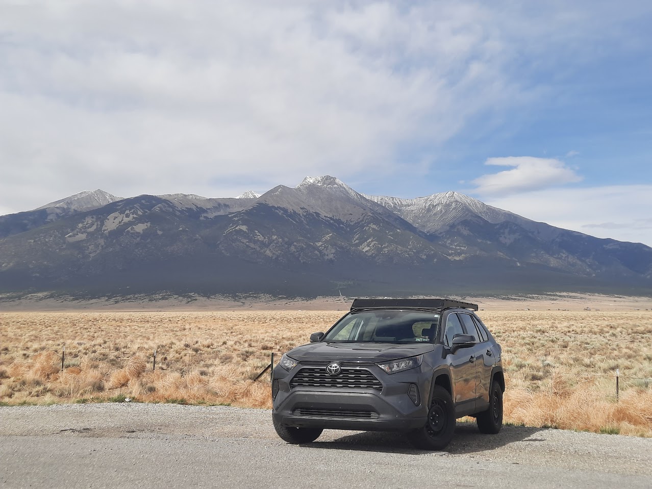 magnetic gray metallic rav4 parked with mountain in background